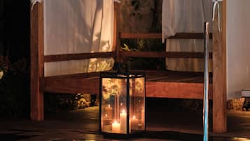 A wooden bench with a canopy, a glass lantern, and a pool with blue lighting.