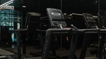 Ein Fitnessstudio mit Laufbändern und Kraftgeräten, gestaltet in modernem Stil mit geometrischer Beleuchtung.