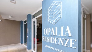 A hallway with a blue wall displaying the text "OPALIA RESIDENZE" and "GARDALAKE LIFESTYLE". - Opalia Residence - Eva's Elegance (Peschiera del Garda)
