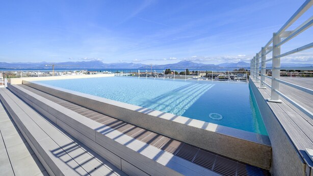 A rooftop infinity pool with a clear view of mountains and the sea. - Opalia Residence - Eva's Elegance (Peschiera del Garda)