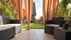 An outdoor patio area with wicker furniture and a pergola with curtains. - Langhe Wine & Relax (Piemonte)