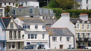 A coastal town with a mix of residential and commercial buildings, including a hotel named "The St Mawes Hotel". - Crows Nest: a modern apartment in the centre of St Mawes with stunning sea views (St Mawes)
