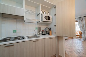 Jääkaappi, mikroaaltouuni, liesi, keittoastiat/astiat/ruokailuvälineet