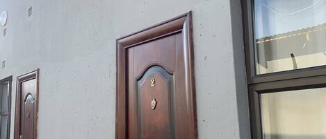 Ein Gebäude mit einem großen Fenster und einer Holztür, auf der die Zahl 2 angebracht ist.