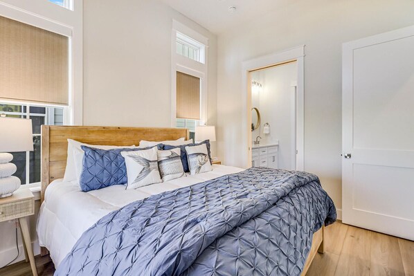 A bedroom with a wooden headboard, a large bed with a blue and white patterned duvet, and a bedside table with a lamp.