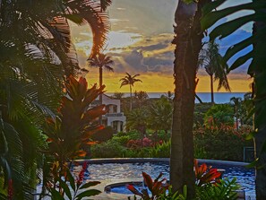 A resort with a pool, palm trees, and a view of the ocean at sunset. - Elegant Wailea Remodeled 2BR Condo Saltwater Pool Steps to Keawakapu Beach (Wailea)