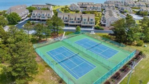 A residential area with two tennis courts, houses, and a view of the sea. - Vacation Rental in the Bayfront Community of Port Lewes (Lewes Beach)