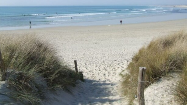 A sandy beach with a wooden fence and grass in the foreground. - Authentic Fisherman’s Cabin • Audierne Bay • Brittany • 2 Guests (Saint-Jean-Trolimon)