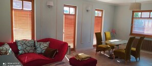 Relax in this stylish living room with a sofa, dining area, and natural light pouring in through the window.