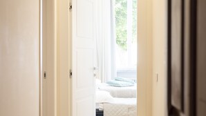 A hallway leading to a bedroom with a bed, a window, and a door. - Sinonda Luxury Apartment (Maiori)