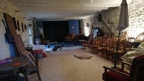 Ein rustikaler Raum mit Steinwand, Holzmöbeln und einer Bühne.