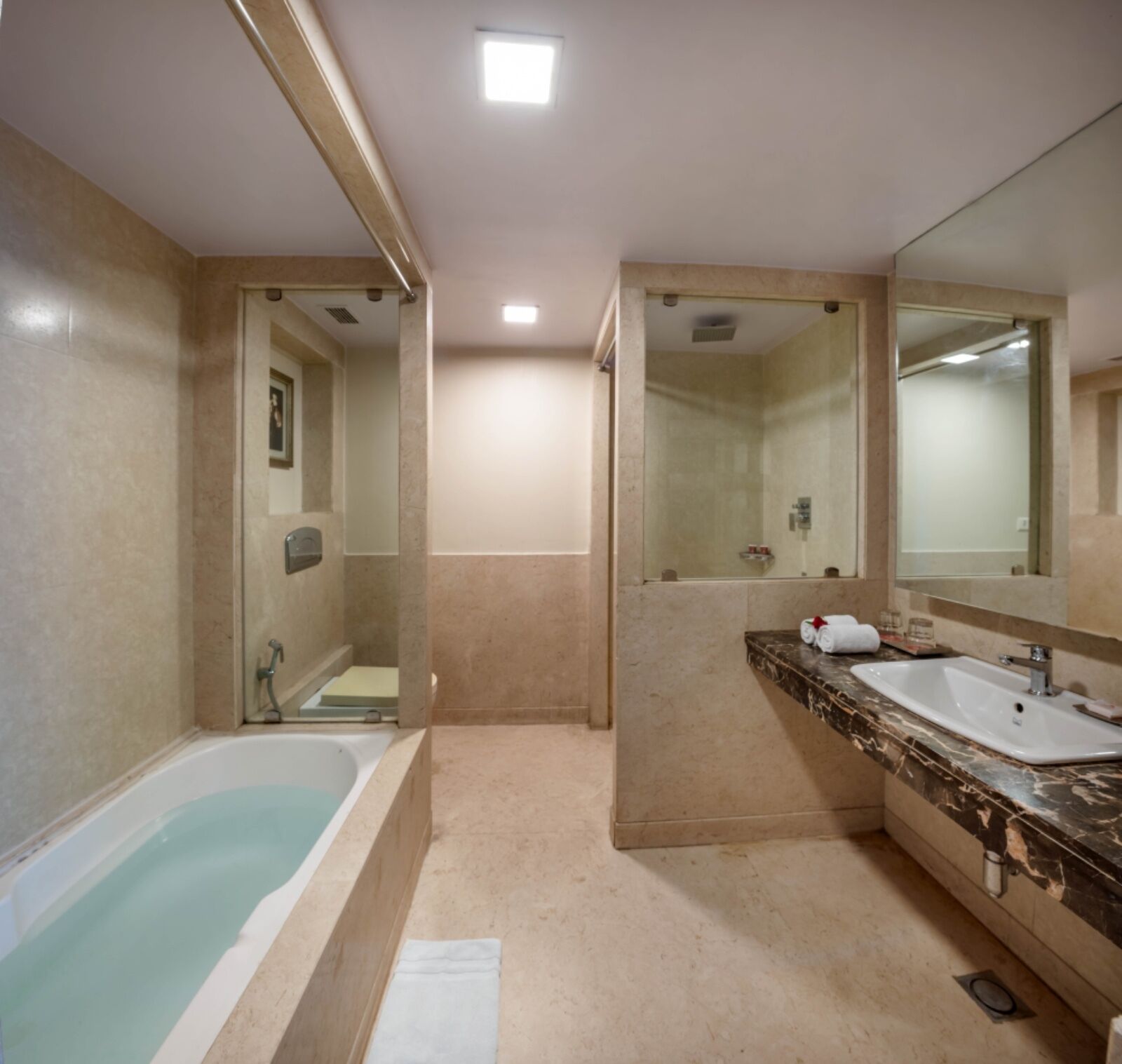 Une salle de bain moderne avec une baignoire, deux lavabos et un grand miroir.