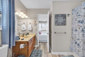 Une salle de bain équipée d’un lavabo, d’un miroir et de porte-serviettes.