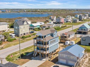 A coastal residential area with houses, a stop sign, and a view of the water.