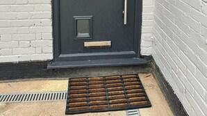 A dark grey door with a vertical handle, a small window, and a number plate reading "20 CHERRY WAY". - The Grey Retreat (Shepperton)