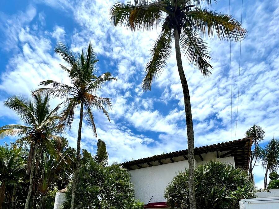 Una casa con fachada blanca, techo rojo y una escalera que lleva a una puerta.