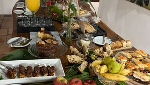 A buffet table with various food items, including fruits, pastries, and sandwiches. - Hotel Casa Paradiso (Guarujá)
