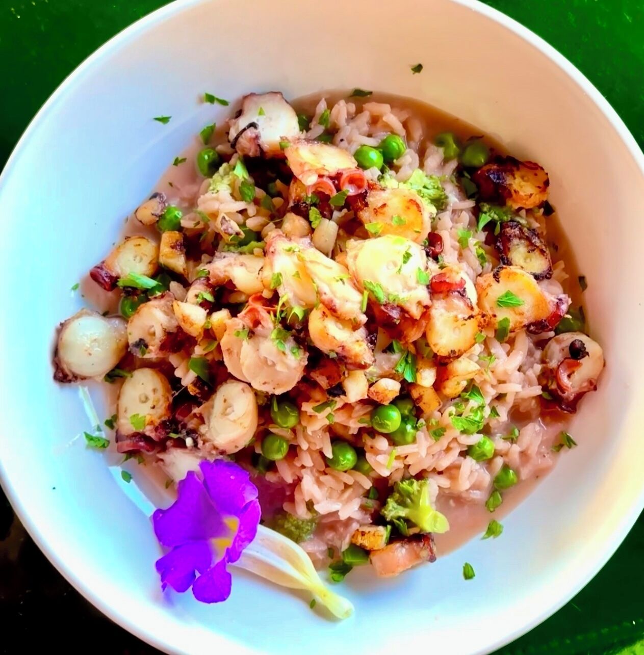 Un tazón de arroz con mariscos y verduras.