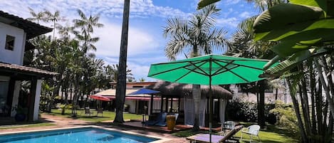 Una piscina al aire libre, sillones reclinables de piscina