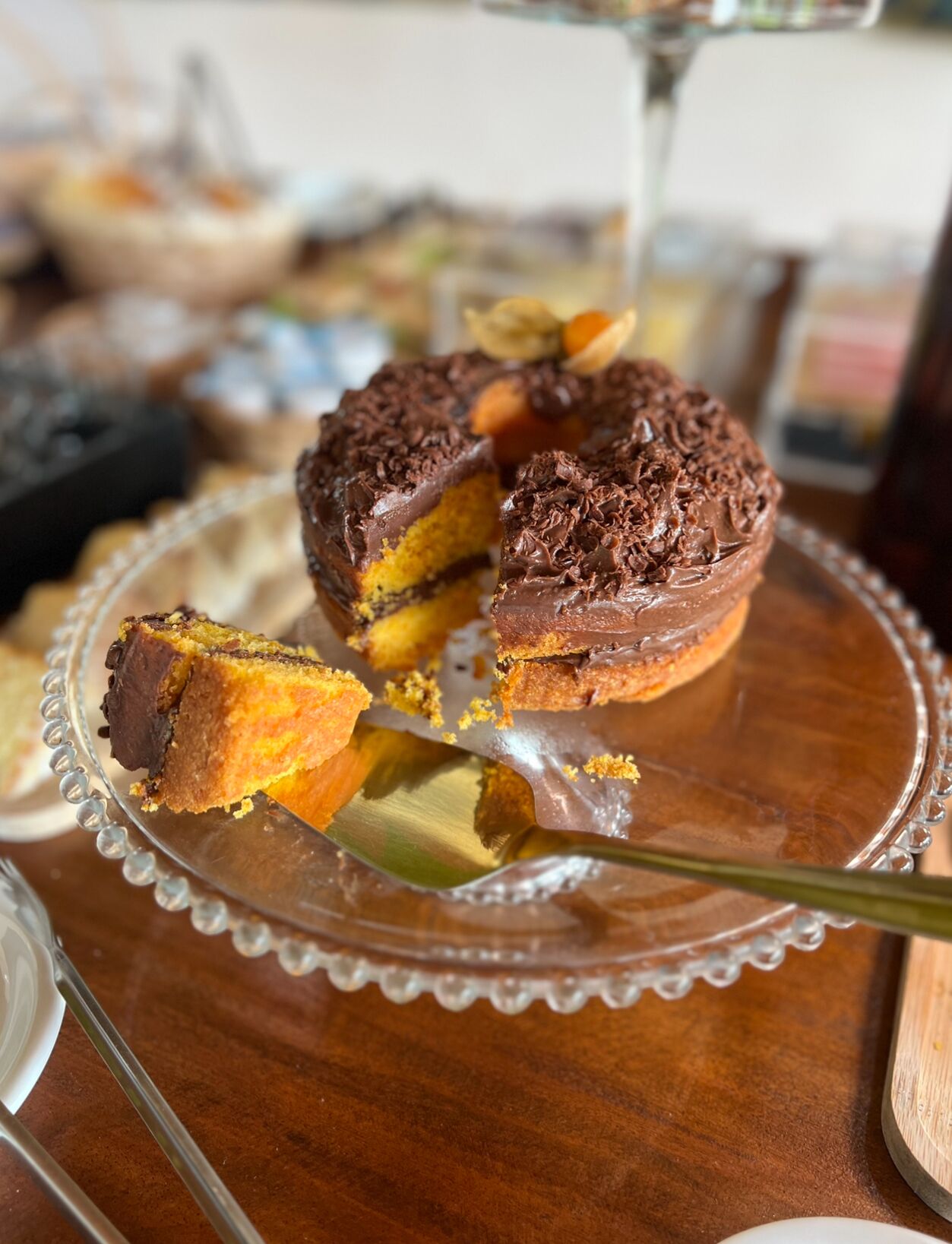 A cake with chocolate frosting on a glass plate.