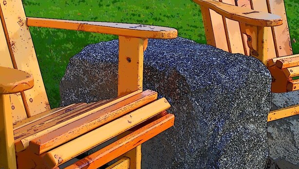 Two wooden Adirondack chairs with a stone bench in a garden area. - Deluxe Ocean View Room (Brooklin)