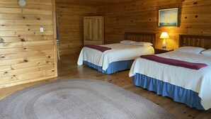 A cabin with two beds, a wooden ceiling, and a painting on the wall. - Deluxe Ocean View Room (Brooklin)
