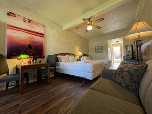 Relax in this serene space with two single beds, a comfortable armchair, and a sofa, perfect for unwinding.