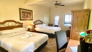 A hotel room with two beds, a ceiling fan, a wooden cabinet, and a desk with a chair. - Lake View Queen Guest Room With Two Queens, Sleeper Sofa And Patio Overlooking Lake Ouachita. 1 Bedroom Hotel Room by RedAwning (Mount Ida)