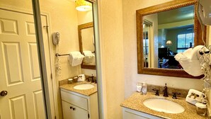 Un baño con dos lavamanos, un espejo, un secador de pelo y un perchero para toallas.