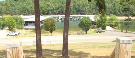 A view of a parking area with a lake and trees in the background.