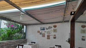 A restaurant with tables and chairs, a 'hello' sign, and heart-shaped decorations on the wall. - Hotel Posada Santa Elena (Tunja)