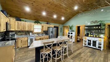 Une cuisine rustique avec des meubles en bois, un îlot en marbre et un coin café.