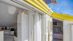 Um apartamento compacto e moderno com cozinha, área de refeições e quarto.