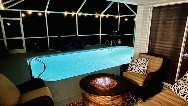 A pool area with a fire pit and outdoor seating.