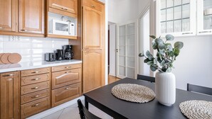Une cuisine moderne avec des meubles en bois, un four à micro-ondes et un coin repas comprenant une table et des chaises.