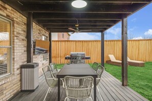 Enjoy dining and socializing in this outdoor patio area, featuring a barbecue grill and comfortable seating for six.