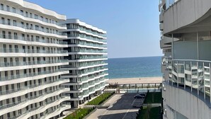 A modern hotel with multiple floors, a parking area, and a view of the beach. - Grup Casa Del Mar (Năvodari)