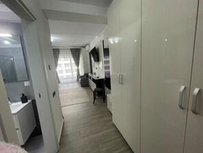 Habitación de hotel moderna con un armario grande, un escritorio y vistas a la ciudad.