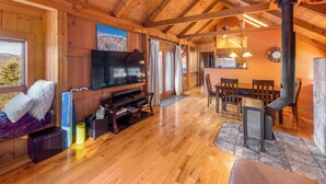 Un interior de madera con televisor, asientos y chimenea.