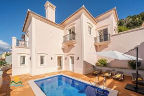A two-story building with a swimming pool, balconies, and outdoor seating. - Palheiro Village villa, priv pool | Palheiro Ocean (São Gonçalo)