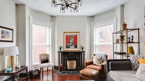 A living room with a fireplace, a chandelier, and a bookshelf. - Stylish Gem in the Heart of Old Louisville (Louisville)