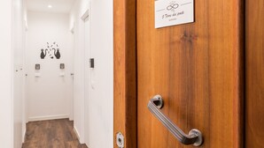 Entrada de una habitación de hotel con puerta de madera, un letrero que indica 5 habitaciones y un picaporte.