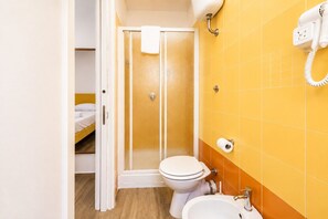 Un baño con ducha, inodoro y lavabo.