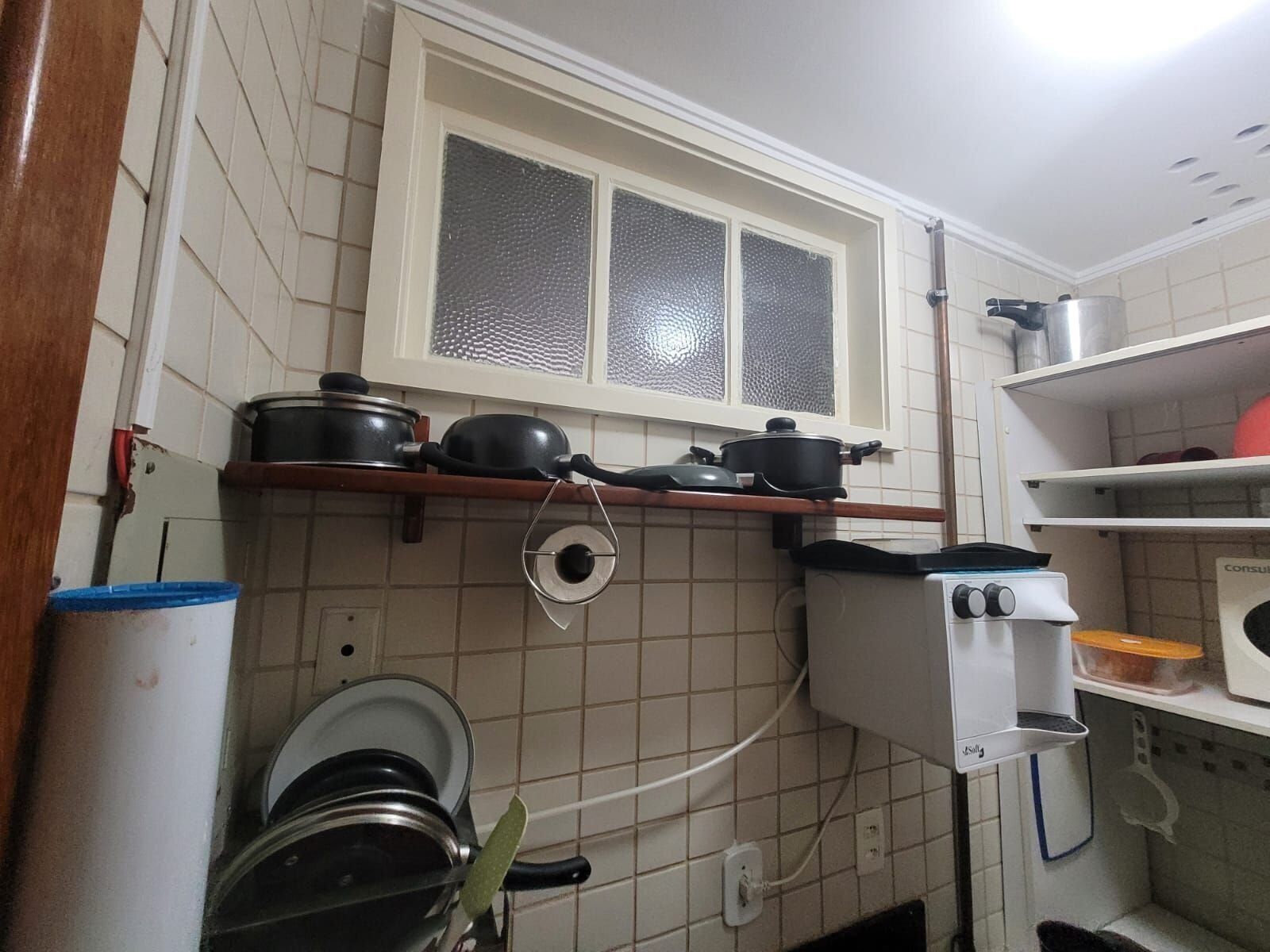 A compact kitchen with a window, a stove, and various kitchen utensils.