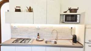 A modern kitchen with a gas stove, stainless steel sink, and a microwave. - Chez Luke Apartment "Vintage" , 10 minutes from "Path of the God" (Pianillo)