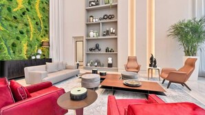 Un salon moderne comprenant un canapé, des fauteuils, une table basse et une bibliothèque.