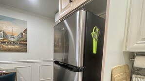 Una cocina moderna con refrigerador de acero inoxidable, armarios de madera y suelo con diseño de espiga.