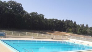 A rectangular swimming pool with multiple lanes, surrounded by a fence and a grassy area with trees. - Cosy cottage in Sauzé-Vaussais with shared pool (SAUZE-VAUSSAIS)