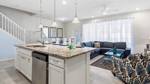 A modern kitchen with granite countertops, a dishwasher, and pendant lighting. - Unforgettable Escape: Private Pool, PS5, Dreamy Resort, Moments from Disney (Kissimmee)