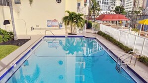 A rectangular swimming pool with a blue border, surrounded by a white fence, and a sign indicating a depth of 8 feet. - Fort Lauderdale Yacht & Beach Club 411 (Fort Lauderdale)